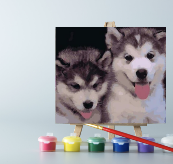 An easel with paints and a Husky puppies paint by number on canvas on it