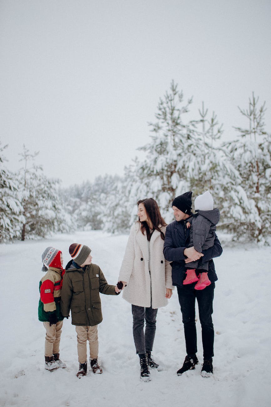 family with three kids standing outdoors in winter