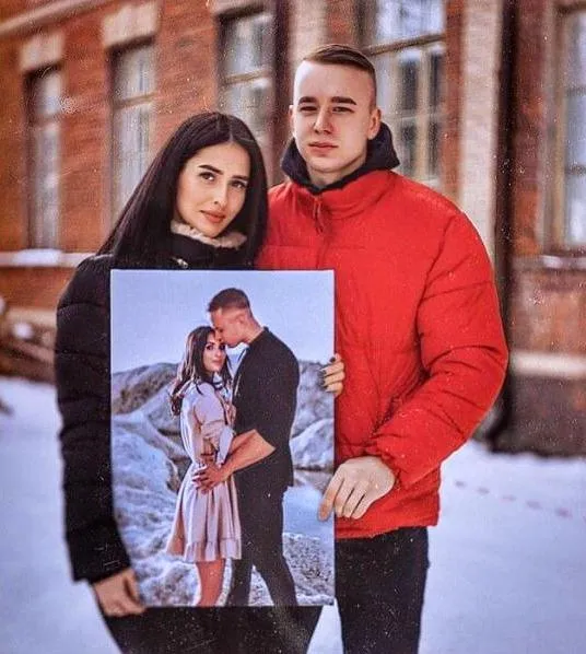 Two people holding a paint by number picture of themselves