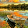 a picture of a boat sitting on the shore of a lake at sunset