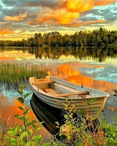 a picture of a boat sitting on the shore of a lake at sunset
